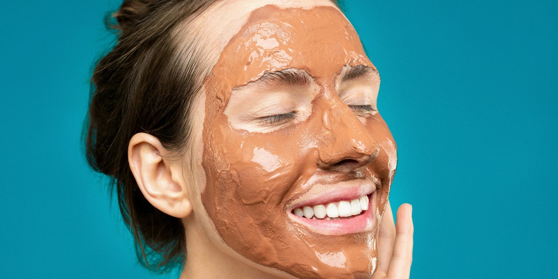 A young woman uses natural masks for skin hydration.