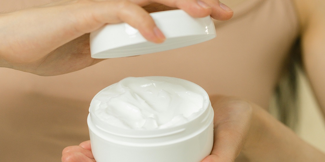 žena koja zna kako treba čitati deklaracije na kremi otvara posudu