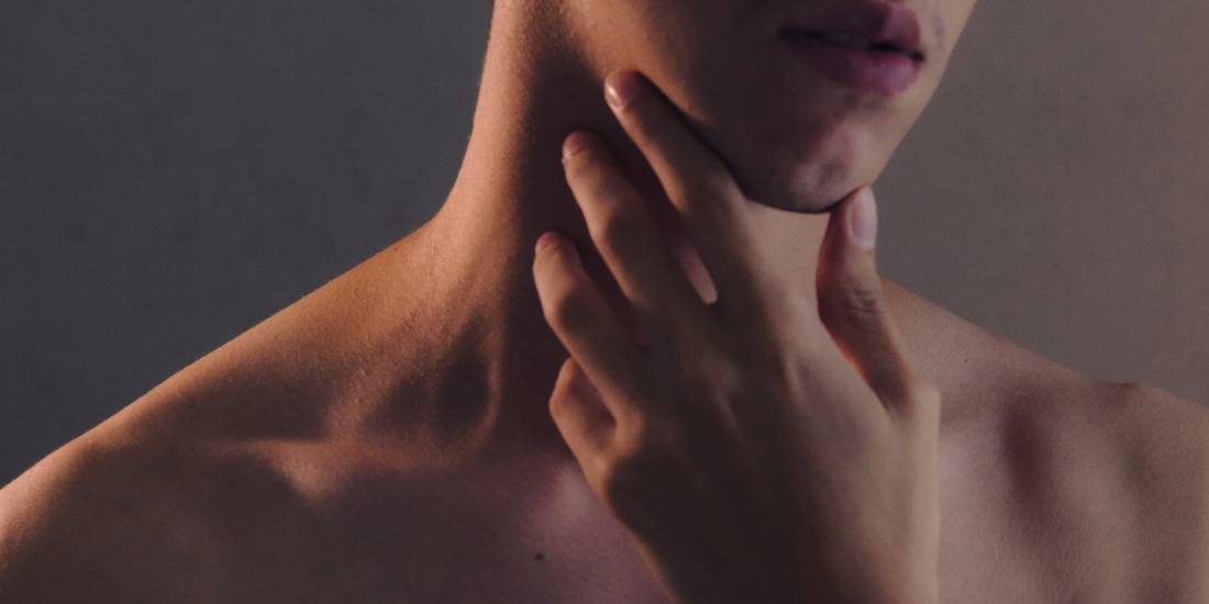 Osoba koja se drži za vrat, što može biti znak da oseća nelagodnost koja je često povezana sa razvojem raka grla.