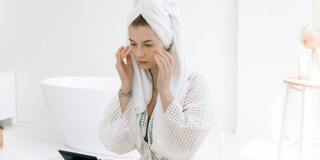 A woman applies cysteamine in cosmetics after showering.