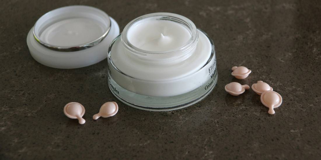 An open jar of cream and care capsules.