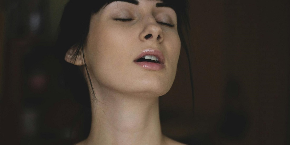 Žena sa zatvorenim očima i napetim izrazom lica