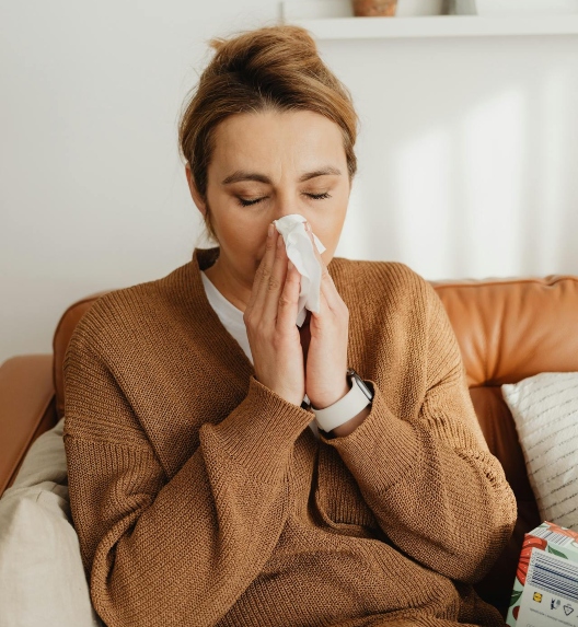 Женщина сморкается из-за аллергического ринита.