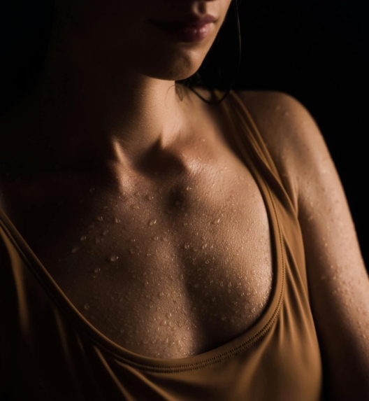 Hyperhidrosis, or excessive sweating in a young woman, appears as visible droplets on the body.