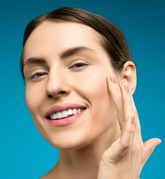 žena pokazuje čistu kožu lica i smeši se