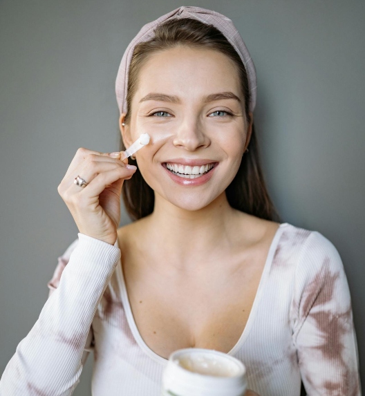 devojka maže kremu na lice