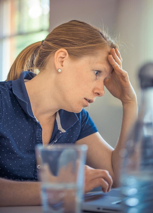 zabrinuta žena sa rukom na čelu