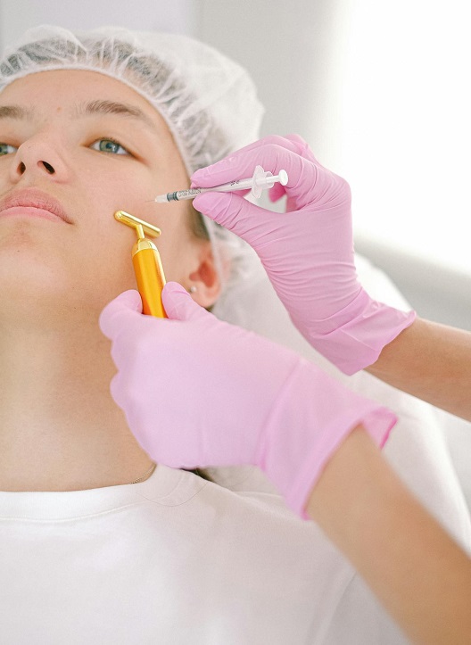 Dermatolog primenjuje tretman na licu pacijenta