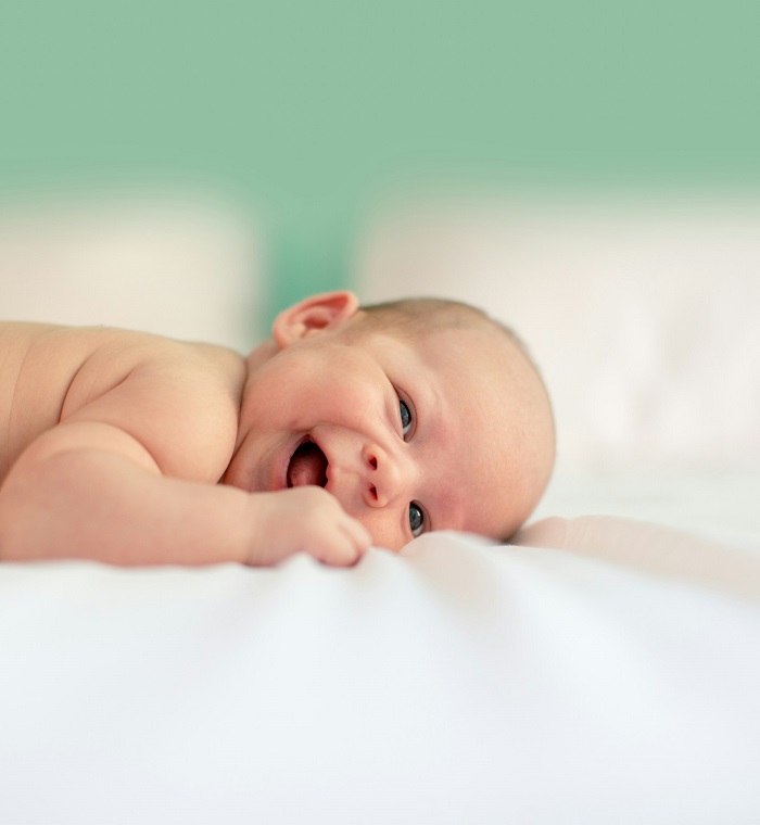 Nasmejana beba na stomaku