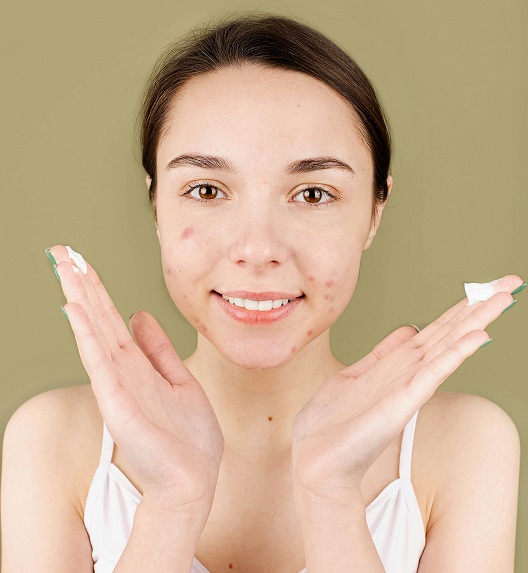 Woman applying cream and taking care of her face.