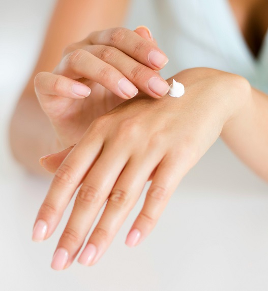 The person is applying cream to their hand.