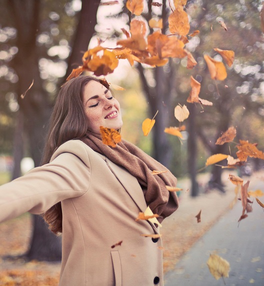 A girl enjoys a windy autumn day.