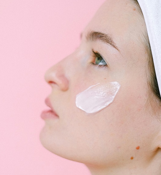 Žena nanosi kremu na obraz