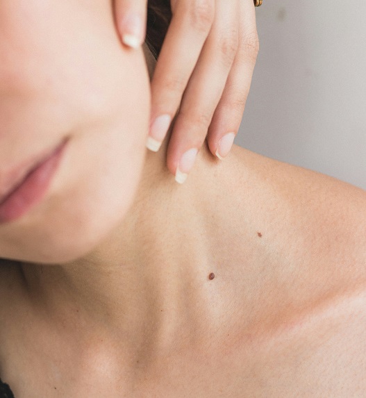 A woman touches her neck while feeling tension and discomfort.