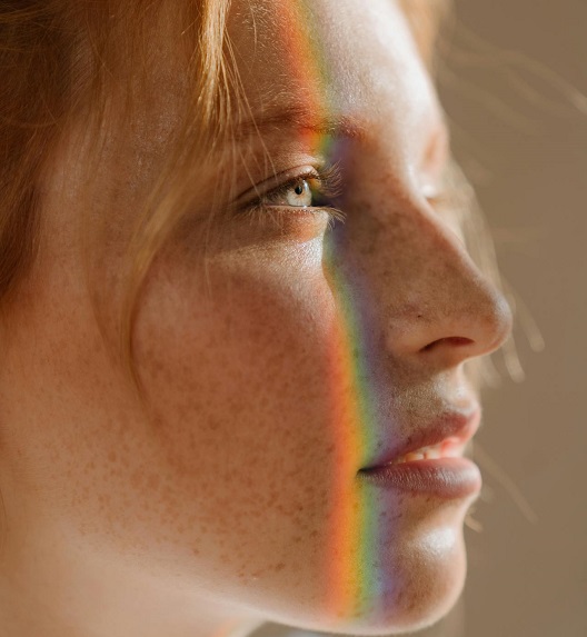 Mlada žena gleda u svetlost, prirodno pokazuje savršen balans profila.