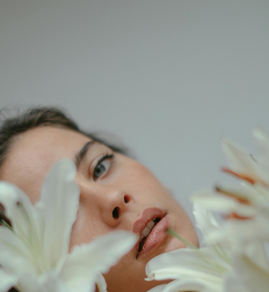 Žensko lice naglašene temporalne zone među belim ljiljanima