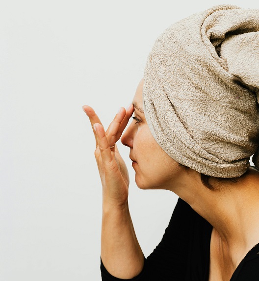 Žena nanosi kremu na lice