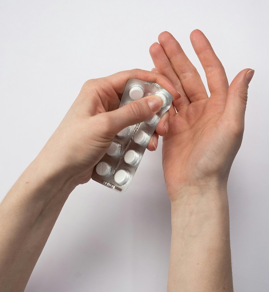 A woman holds a blister pack of tablets