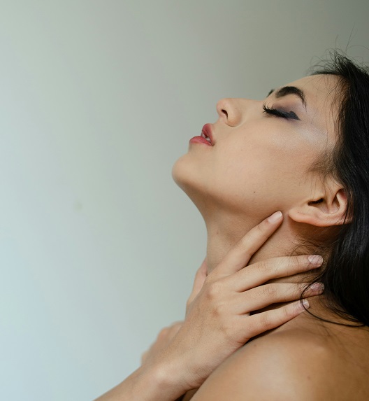 Osoba koja dodiruje vrat, što može biti znak da su simptomi povezani sa razvojem raka grla.