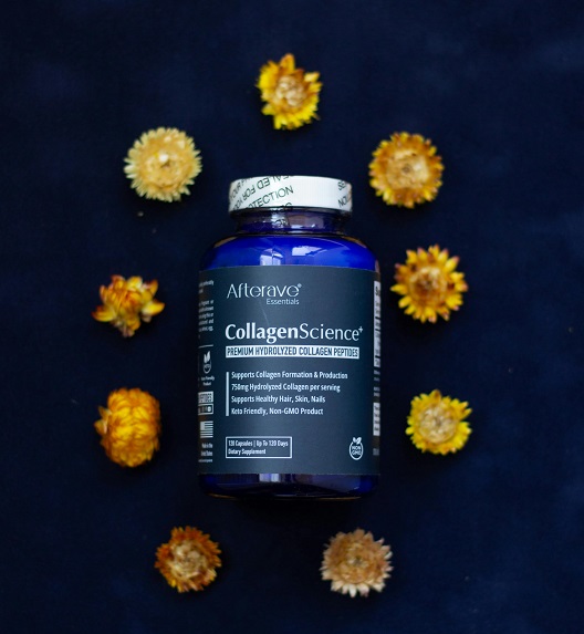 Plava bočica kolagena okružena sušenim žutim cvećem.