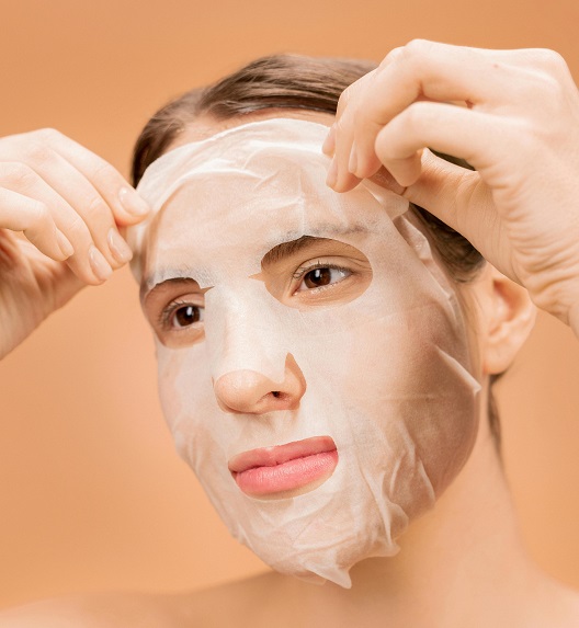 Žena pažljivo skida masku sa lica.